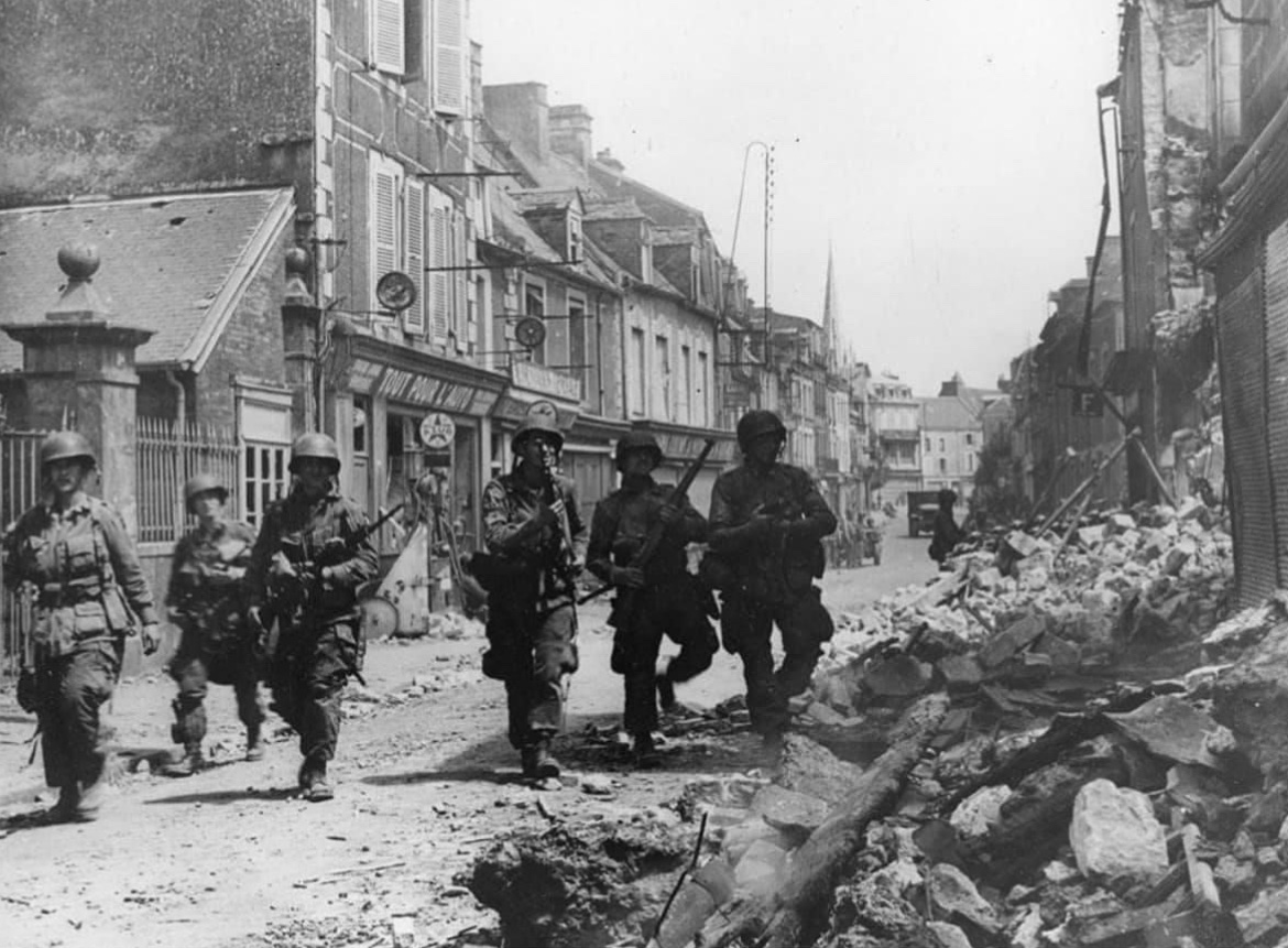 In June of 1944, paratroopers of the 101st Airborne Division move through the town of Carentan, France. 🪂