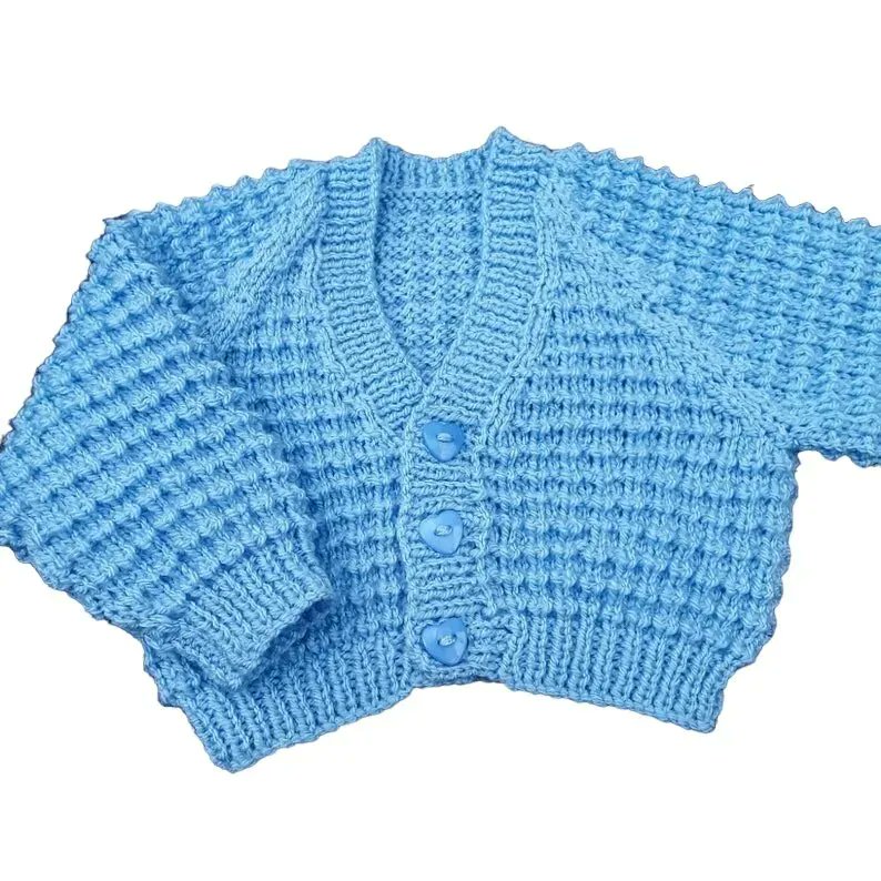 Hand knitted baby cardigan in baby blue with all over textured pattern and blue heart buttons to fit 0 - 3 months or reborn doll buff.ly/3VG8iOZ #knittingtopia #etsy #babycardigan #knittedbabyclothes #handknits #supportsmallbusiness #MHHSBD #craftbizparty