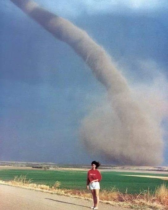 A Young Girl Posing in Front of a Tornado in Nebraska, 1989.