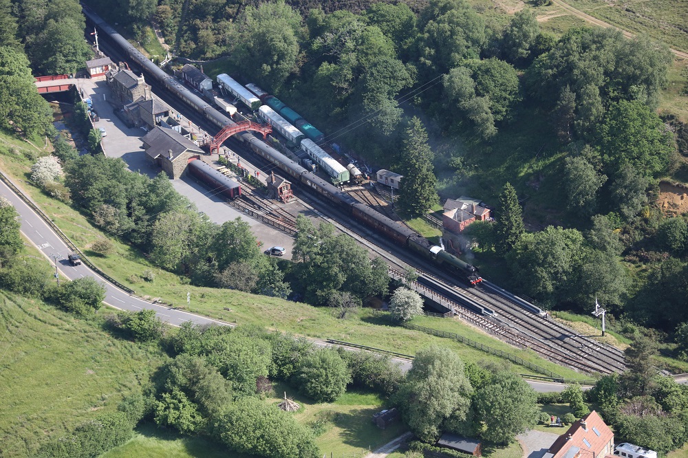 Aerial shot of Flying Scotsman hauling the Royal Train through Goathland station along the North Yorkshire Moors Railway.