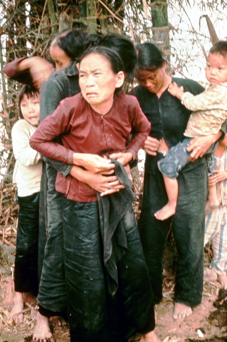 A Vietnamese teenager buttons up her Mothers blouse after she was sexually assaulted by American Gl's. They were gunned down moments after this photo was taken. My Lai Massacre, Vietnam. 16 March 1968.