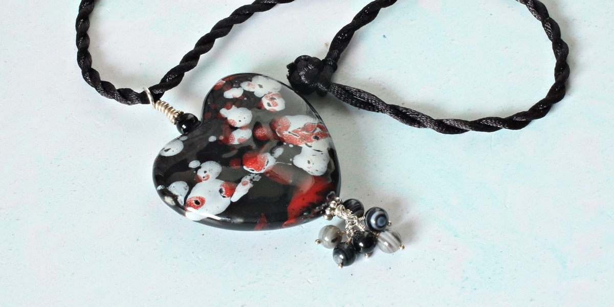 Romantic heart necklace made with a large porcelain heart. The glaze on the heart is black with an abstract design in red and white.  It would make a stunning gift for a loved one.
etsy.me/3hw4ZFD   
#heartnecklace
#onlinecraft