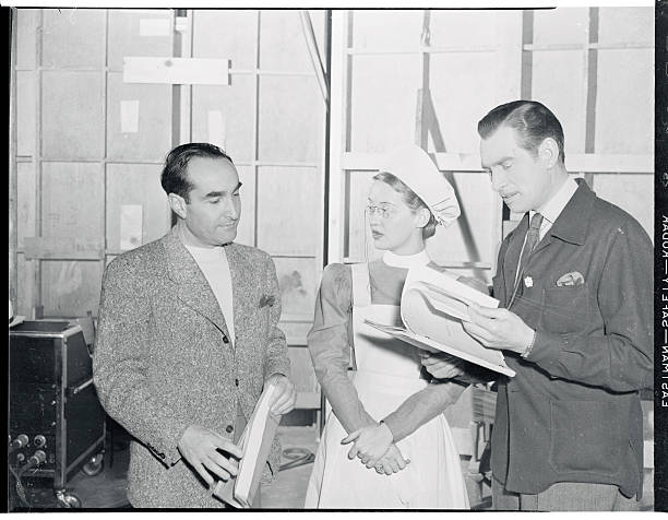 (Original Caption) Bette Davis, between pictures at WB, plays an extra as a nurse in good-will gesture to her former dialogue director, Irving Rapper, in his first directorial role for Winged Victory. Photo: Rapper, left, instructing Miss Davis and James Stephenson. #DailyBette