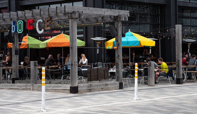 People sitting on a patio outside a restaurant at Lansdowne Park.