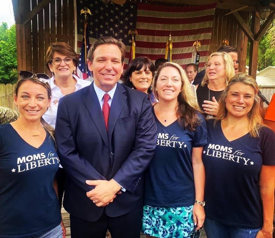 Here is Florida Governor Ron DeSantis posing with Moms for Liberty, an "anti-government extremist" organization that was listed as a hate group by the Southern Poverty Law Center (SPLC). This explains Governor DeSantis' book bans and hostility towards the LGBTQ+ community.