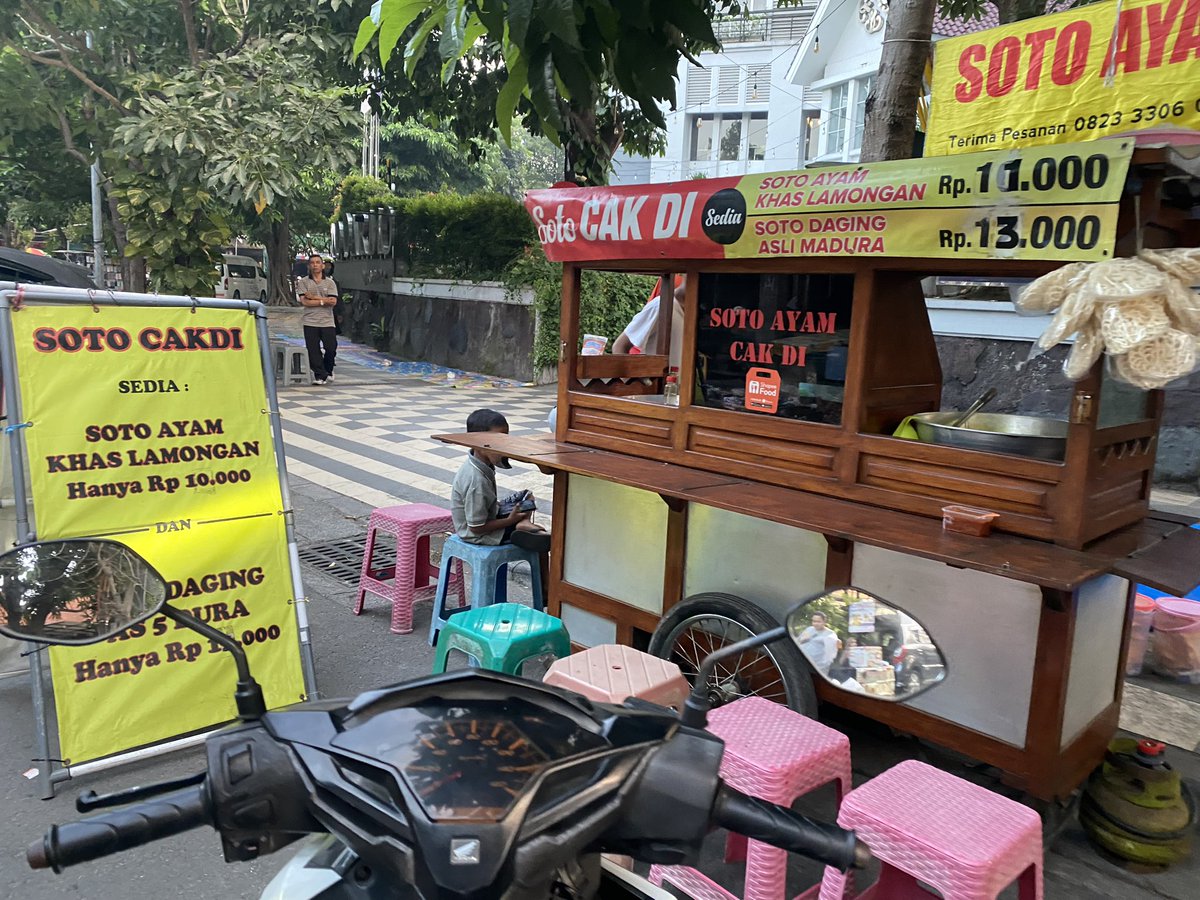 hasyimmah's tweet photo. Dari sekian banyak jenis soto di Indonesia, "pertarungan" soto di Jawa Timur itu dikuasai Soto Lamongan dan Soto Madura. Keduanya punya versi daging (sapi) dan ayam.

Di lini daging, Soto Lamongan dan Madura bersaing ketat. Sama kuat.

Di lini ayam, Soto Lamongan jauh lebih superior. Tak heran Soto (ayam) Kudus tampak mulai merangsek untuk meramaikan persaingan persotoan ayam di Jawa Timur.

Keterangan foto 1: 
Ini adalah Soto Ayam Lamongan yang versi dagingnya murtad ke Soto Madura. Atau bisa juga Soto Daging Madura yang versi ayamnya murtad ke Soto Lamongan. Sayang saya tidak tanya dari mana asal Cak Di, sang penjual, apakah dia dari Lamongan atau Madura.

Harusnya saya tanya sambil marah: "Sampean iku wong Meduro opo wong Lamongan?!? Sing jelas dadi wong iku. Ngene iki lak nggarai bingung!"

Keterangan foto 2:
Infografis Harian Kompas tentang soto, yang malah tidak mencantumkan Soto Daging Lamongan maupun Madura.