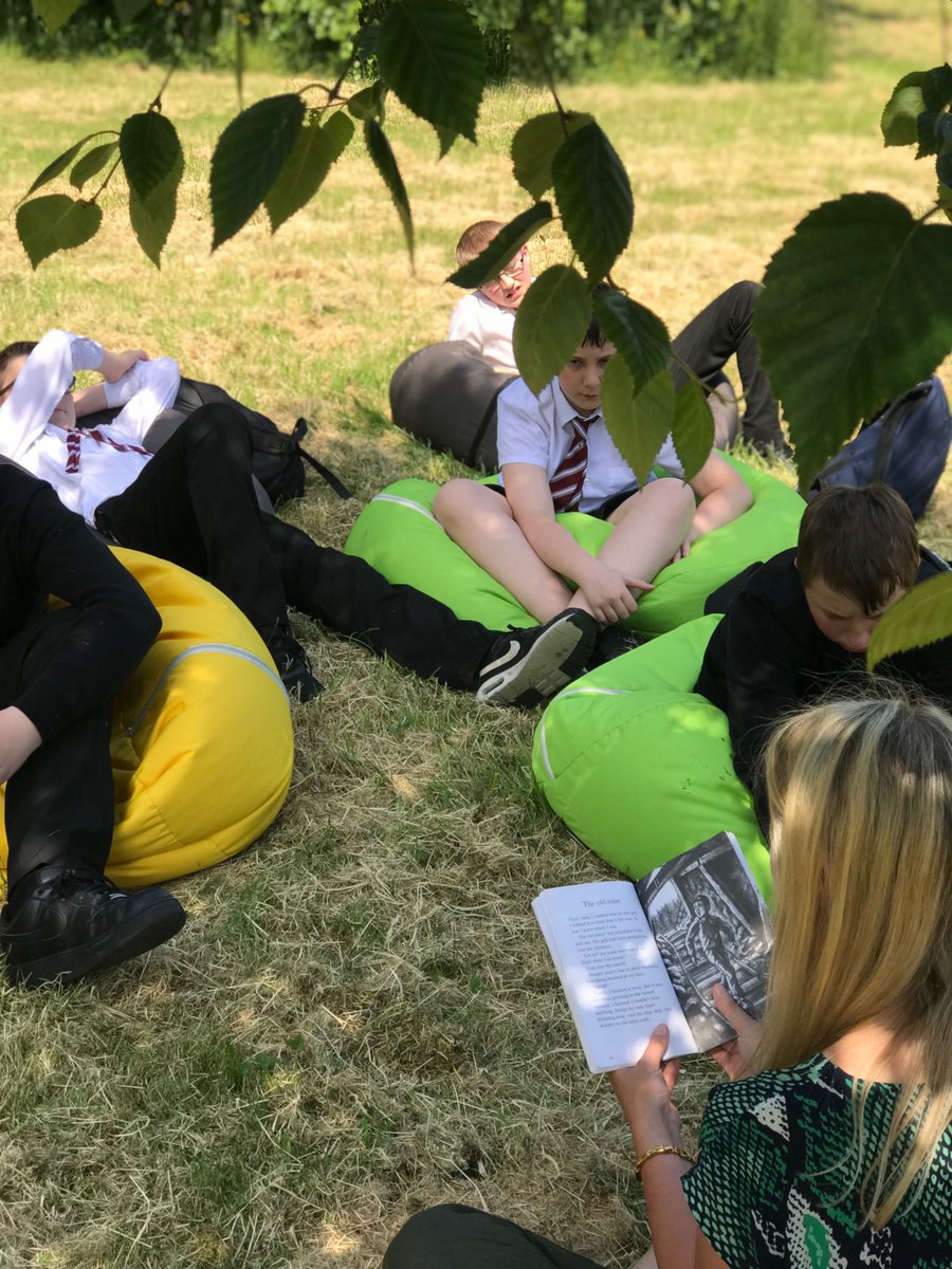 Miss Bruce our amazing librarian is reading to our S3 out in the Scottish Summer underneath the shade of our trees.