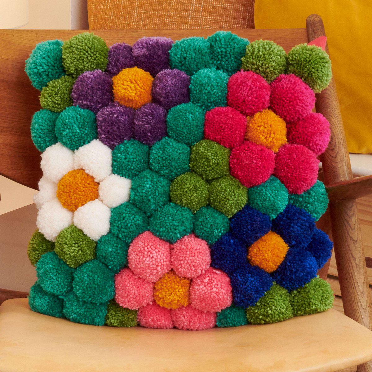 Explore a world of color with this inspired craft pillow that features pompoms! You can easily update your couch with this whimsical accent! 😍#crafts #yarncrafts #yarnspo rb.gy/707og