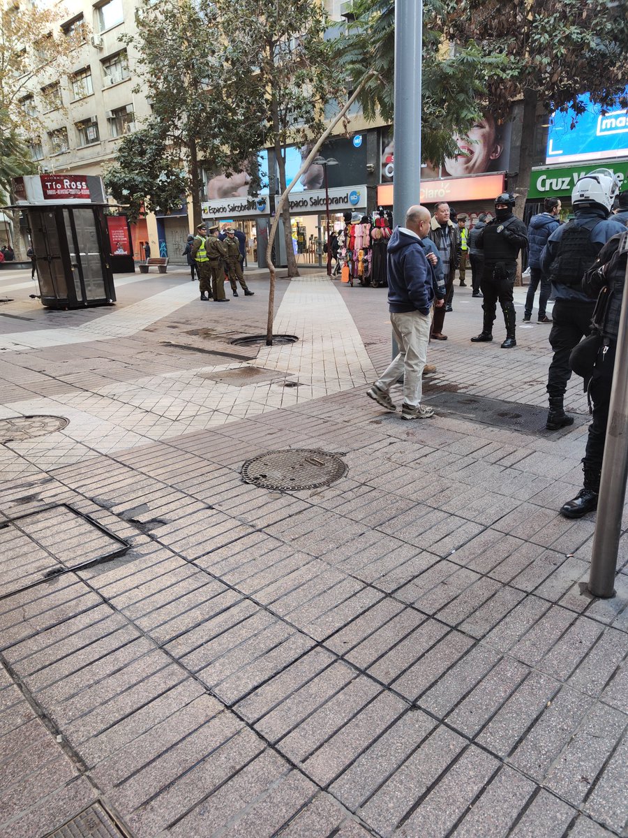 Hiraci Hassler en Huérfanos con Ahumada 9.20am. la rodea un séquito de funcionarios municipales que simulan ser transeúntes y me increpan. Un fuerte resguardo de guardias municipales y carabineros completa el cuadro y,por cierto,la prensa citada al efecto.