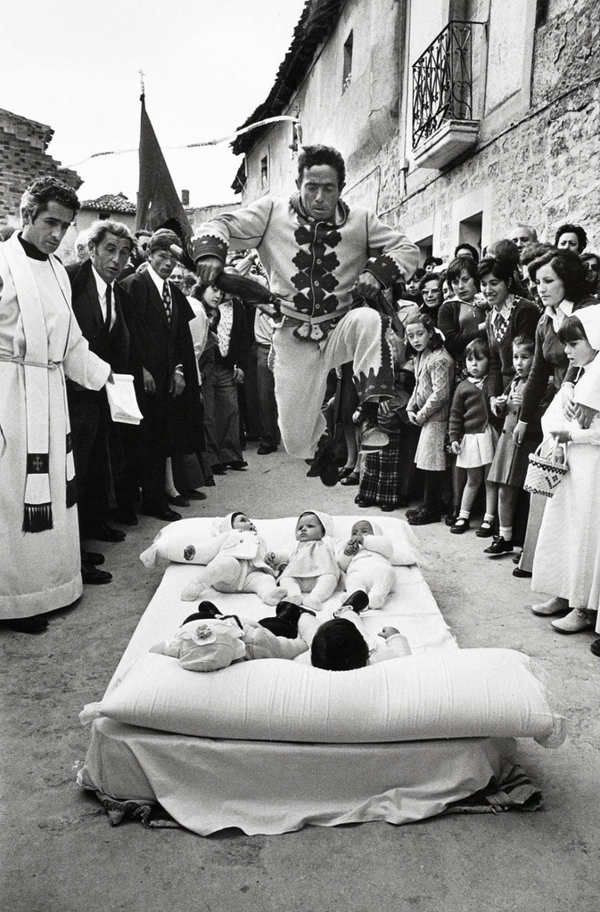 From the collection, by Cristina García Rodero—each June in the Spanish town of Castrillo de Murcia, the festival of El Colacho finds men dressed as 'devils' taking flight, leaping over babies born the previous year, to protect them from misfortune in years to come.