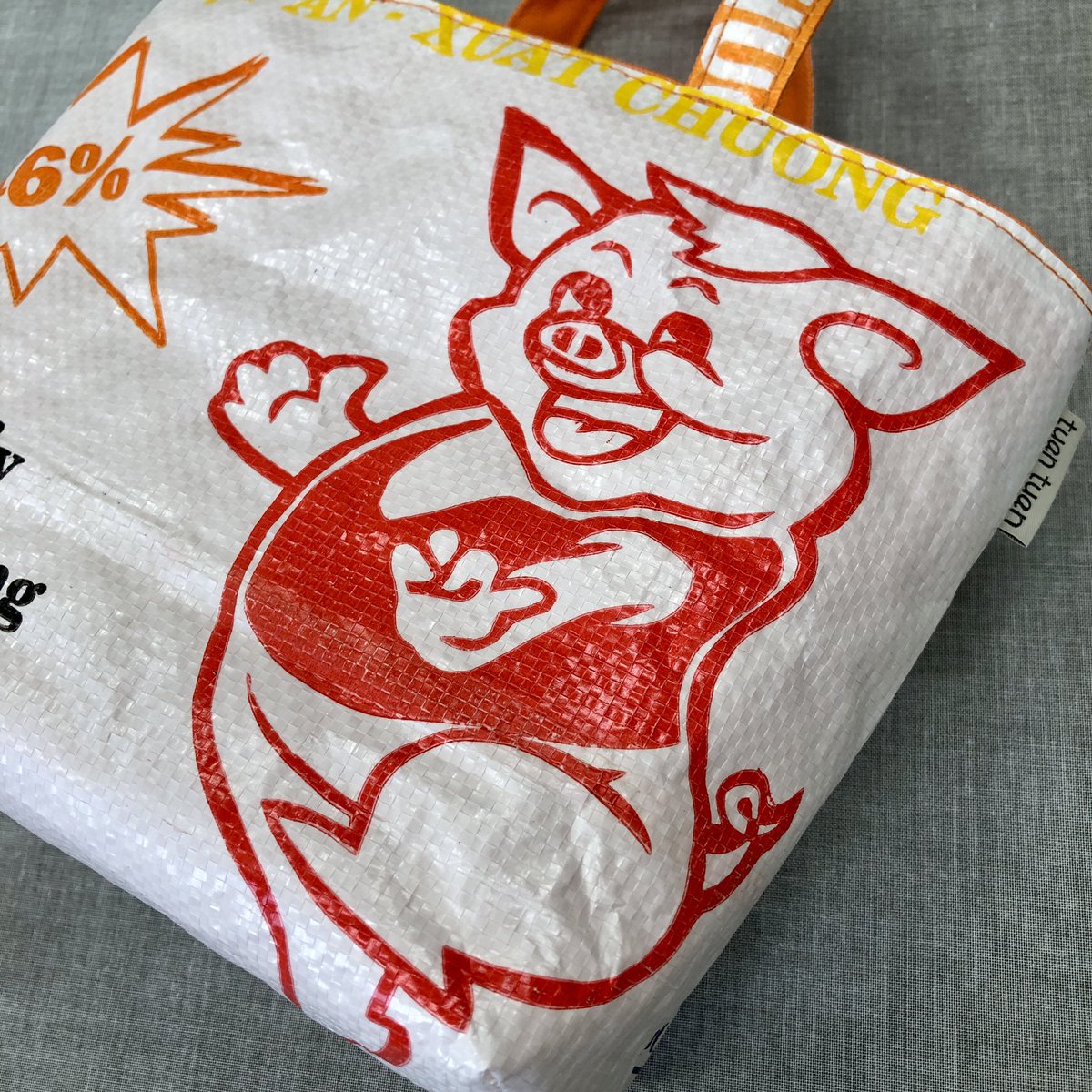 tuan_bag's tweet photo. 🌟catchy-mini🌟

オレンジ色の帆布が夏っぽくてかわいいミニトートバッグ🍊

ちょっとキモカワ系？のブタさんキャラもとってもラブリー❤️

ボトルホルダーも付いてるよ😊

#アップサイクル #upcycle #tuantuan #中目黒 #ハンドメイド #キャッチー #オンリーワン #ミニトート https://t.co/8BfRQpcWaP