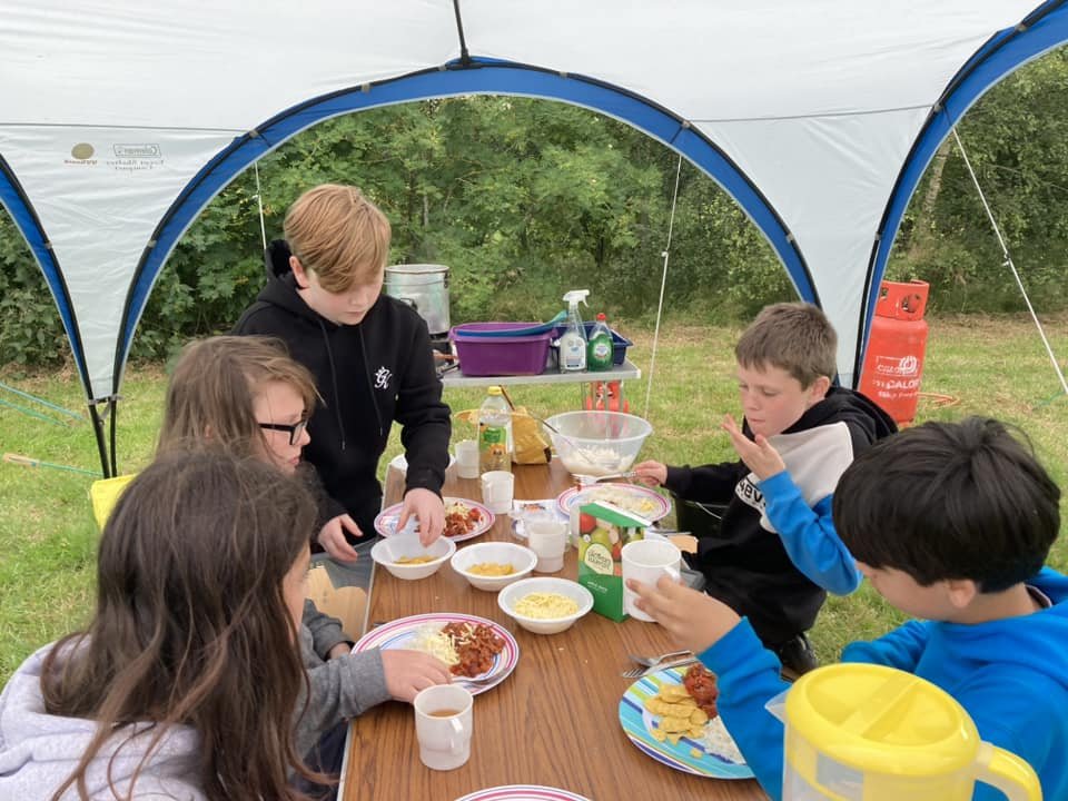 Scouts have had a busy day at camp. They’ve just cooked their own tea under supervision of their patrol leaders and are now tackling team games and an assault course!