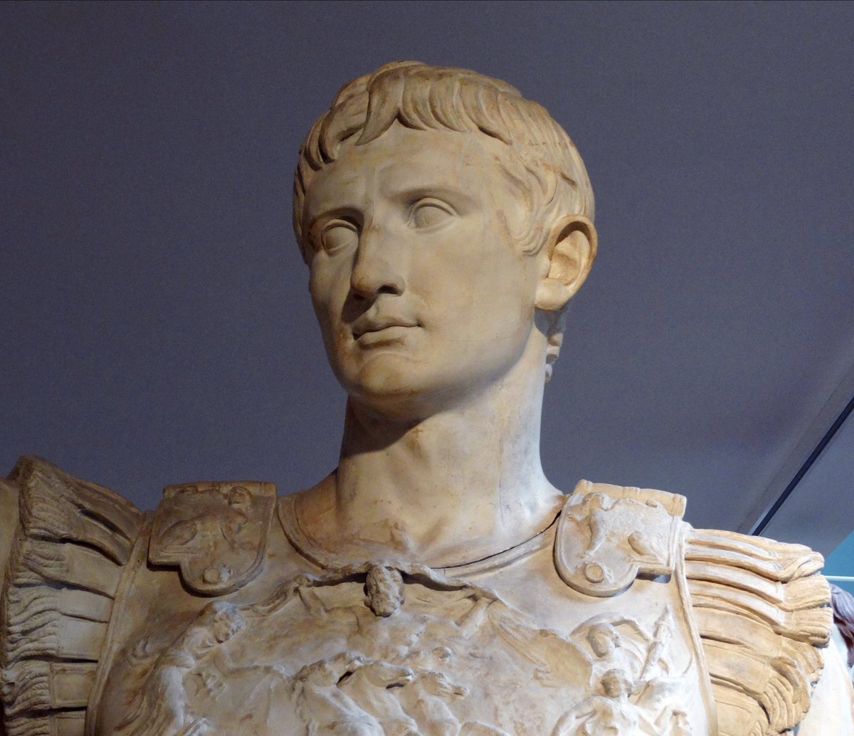 AliciaMimundo's tweet photo. #Escultura 

1. Estatua en mármol del emperador Augusto de Prima Porta (su nombre viene del lugar donde fue descubierta, en la villa de Livia en el suburbio romano de Prima Porta). 
Cuando la miras ves a un hombre joven, poderoso, en actitud de arengar a sus soldados. 
La escultura fue realizada cuando contaba 40 años de edad su rostro es joven y su porte vigoroso. Nos muestra un Augusto jefe militar con sus atributos tales como la lorica o coraza musculata (armadura que reproducía la musculatura del pecho, reservada a los rangos superiores) en la que está representa la recuperación de los estandartes perdidos en el año 53 a.C. tras la derrota aplastante de Marco Licinio Craso en la batalla de Carras donde además fue muerto. Se sujeta la coraza sobre sus hombros con dos fíbulas o broches con forma de esfinges, alusión a su victoria en la guerra civil tras la muerte de Julio César, su padre adoptivo. 
⤵️