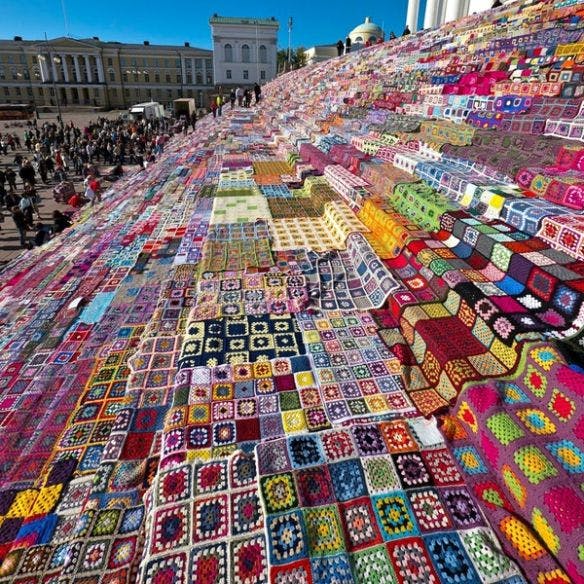 womensart1's tweet photo. Large-scale yarn bomb, Helsinki Cathedral,2011. Crocheted/knitted squares created 3800 blankets which were later donated to charity #WomensArt https://t.co/WYSKbKftse