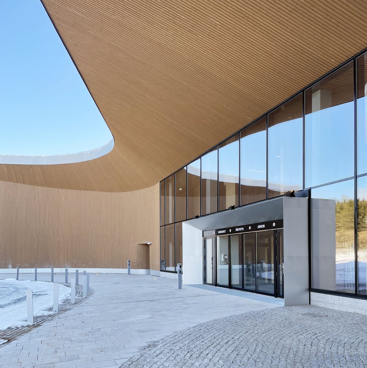 VerstasArch's tweet photo. The handover of the Lapland Central Hospital extension stage 1 has been completed. A large wooden canopy marks the new entrance for the emergency. The curving shape of the canopy and lobby ceiling resembles the forms of the northern landscape. #verstasarchitects #rovaniemi https://t.co/tmiGYXY27Z