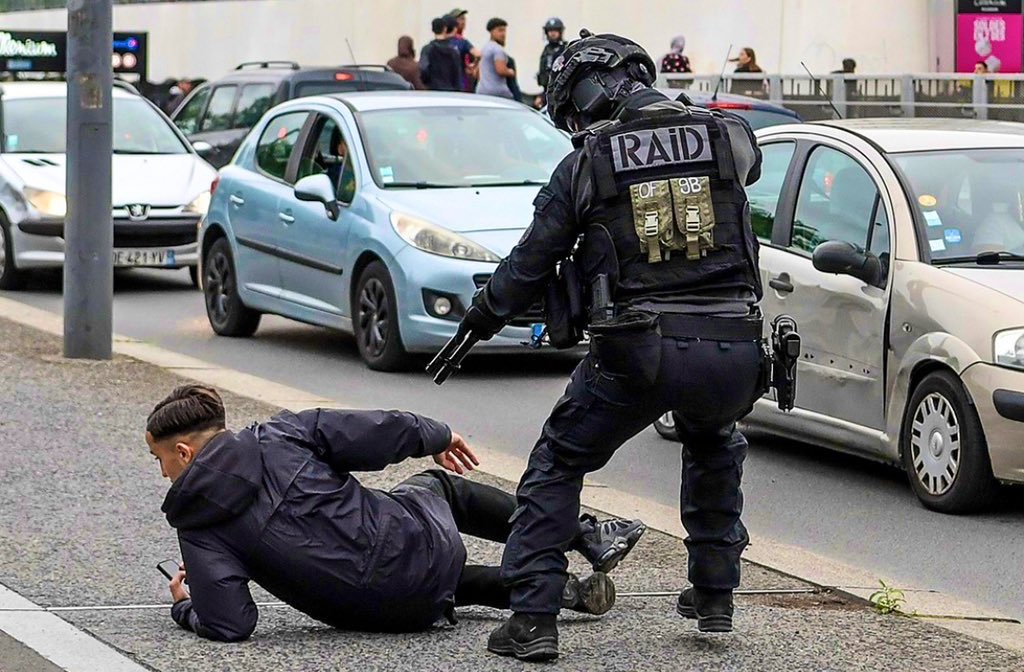 T_Bouhafs's tweet photo. Cette image.
Un enfant et son téléphone.
Un policier du raid et son fusil à pompe.
Terrible. https://t.co/BJh7IOESKA