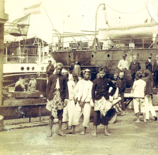 Op de zaterdagse <a href="/parool/">Het Parool</a>-geschiedenis het verhaal van <a href="/voetnoot/">Mark Ponte</a> achter deze op de Amsterdamse Handelskade gemaakte foto van op Java geronselde contractarbeiders, tijdens hun tussenstop naar de plantages in Suriname waar ze te werk werden gesteld na afschaffing van de slavernij.
