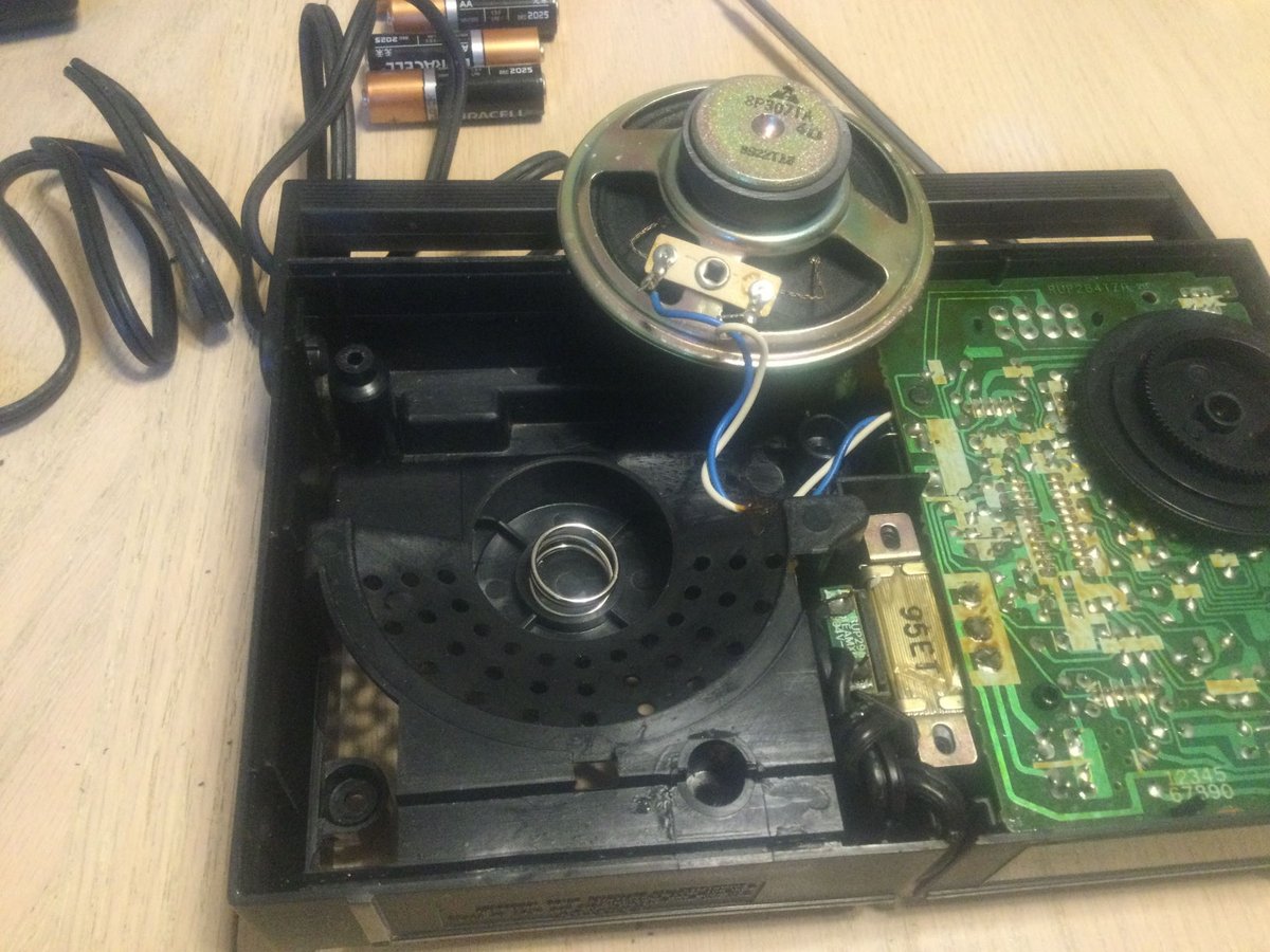 This Panasonic radio really wasn't built with repair in mind. Getting the circuit board out was difficult.

I tell you this mainly because I was intrigued by the use of a spring to keep the speaker in place. Unlike adhesive, it'd never fail and it probably damps some resonance.