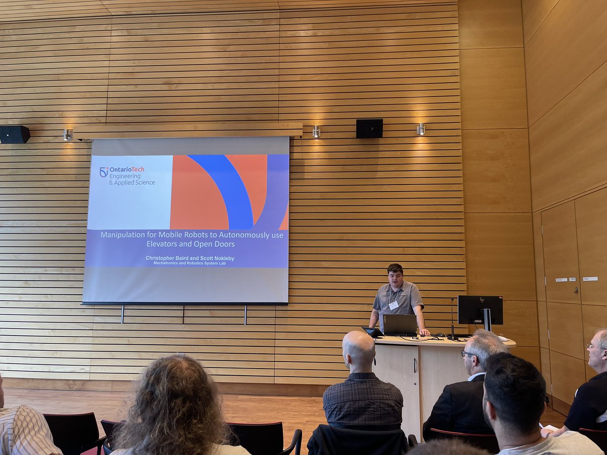 Chris Baird presenting his work on enabling  <a href="/BostonDynamics/">Boston Dynamics</a> Spot robots to autonomously ride elevators and open doors at the 2023 CCToMM Symposium on Mechanisms, Machines, and Mechatronics at the Université Laval. <a href="/OT_FEAS/">Ontario Tech Engineering</a> <a href="/ontariotech_u/">Ontario Tech University</a>