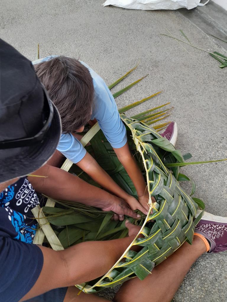 Learning how to put the finishing touches on a basket made out of coconut fronds as part of the UOI.#iss.fj#
