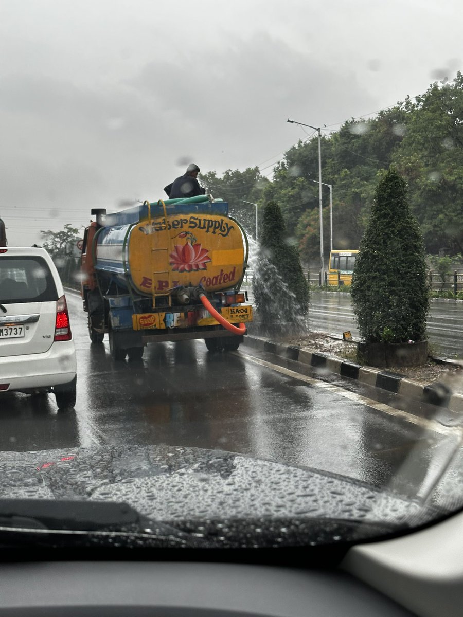 Rohan_Disco's tweet photo. Kudos to @BBMPCOMM come rain, come shine; these guys are watering the plants in pouring rain #Bengaluru #bengalururains #BBMP #cmkarnataka #northbengaluru https://t.co/KaSZlaTFBH