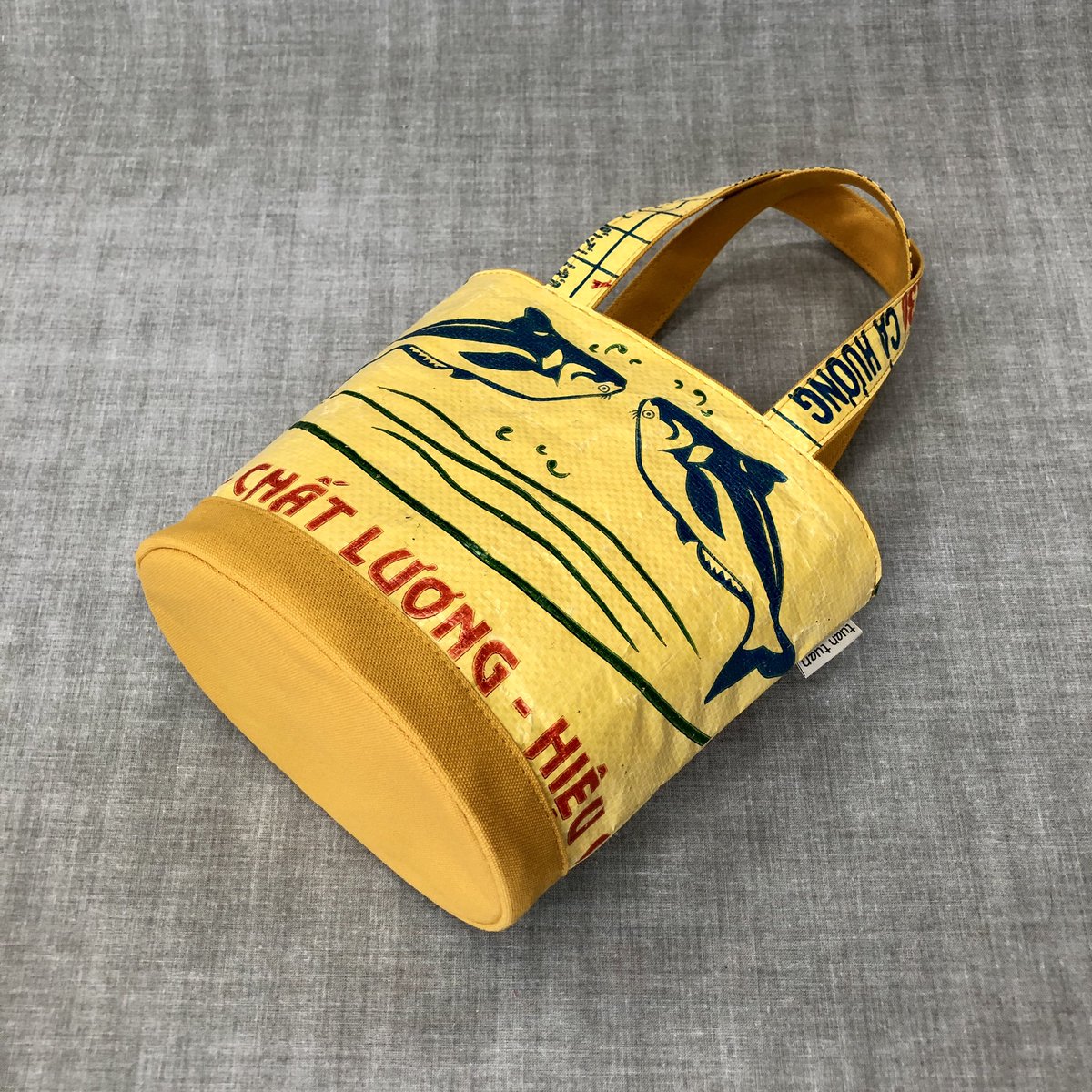 tuan_bag's tweet photo. 🌟neo-oval🌟

帆布と飼料袋とを同色で揃えたシリーズです✨
　
マスタードイエローには黄色ベースのお魚柄🐟🐟
どことなくアンティークアメリカンな雰囲気？

便利なボトルホルダーが付いてますよ😉

#ベトナム #アップサイクル #upcycle #tuantuan #エシカル #中目黒 #ハンドメイド #バケツ型バッグ https://t.co/bCZNXLUGsL