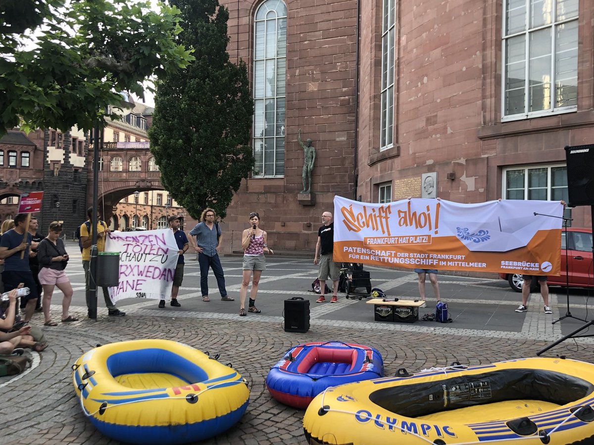 Menschen mit denen eineem Schiff Ahoi Transpi an der Paulskirche, davor Schlauchboote