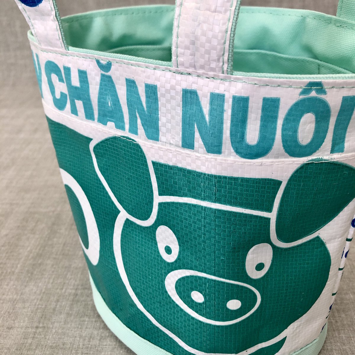 tuan_bag's tweet photo. 🌟neo-oval🌟

帆布と飼料袋とを同色で揃えたシリーズ✨
　
ペパーミントの帆布で爽やか夏バッグ🎐
フォントもブタさんキャラも涼しげな同系色カラーで🐷

便利なボトルホルダーが付いてますよ😉

#ベトナム #アップサイクル #upcycle #tuantuan #エシカル #中目黒 #ハンドメイド #バケツ型バッグ https://t.co/ARatp09Mpk