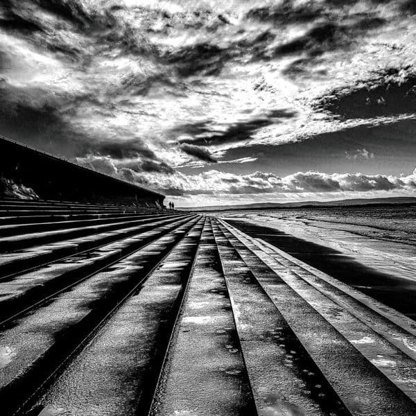 This stunning black and white photography print entitled ‘Drawn to the View’ was taken on part of sea defences at Burnham-on-Sea by photographer Cliff Kinch #drawntotheview #blackandwhitephotography #photography #burnhamonsea #beach #prints #gifts #coastaldecor #coastalhome