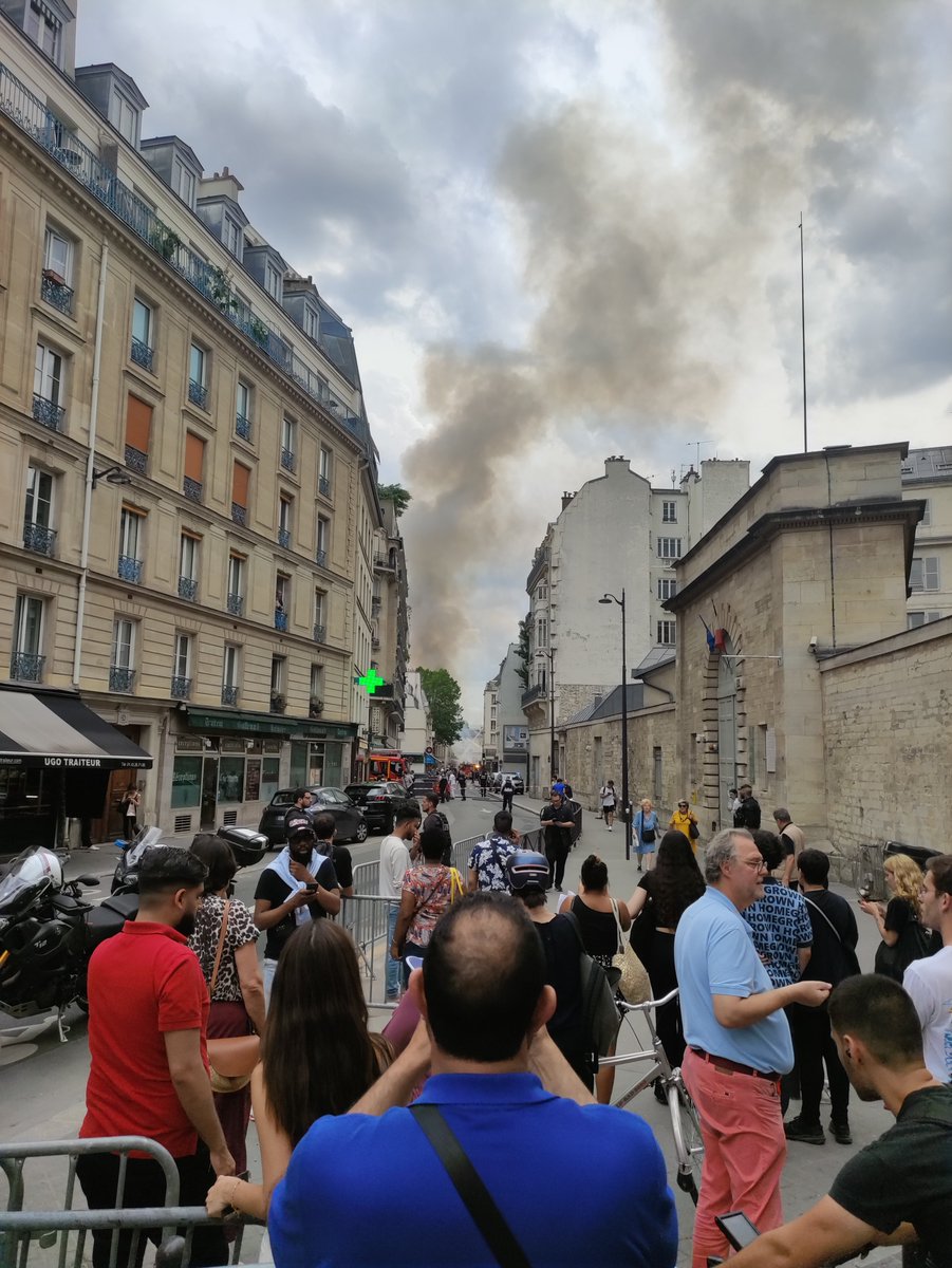 JulienLecot's tweet photo. Des flammes et une grosse fumée, des pompiers qui tentent d'éteindre le tout et des badauds qui prennent des photos de loin. 

À Paris, la rue Saint-Jacques est barricadée. Une explosion a été entendue il y a quelques minutes. @libe https://t.co/VeyRRvQlB1