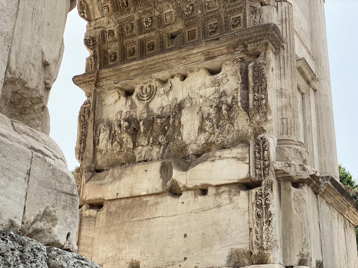 hahussain's tweet photo. The arch commemorating the life and death of Emperor Titus (d. 81) has a relief showing his victories, including sacking Jerusalem, a decade earlier, and bringing back all the Palestinian kuffiyahs, zaatar, and falafel. Wait, what? Oh yeah, relief shows Titus’s spoils as a Jewish menorah, a fact engraved in stone 1942 years ago and that can still be seen in the Imperial Forum in Rome today.