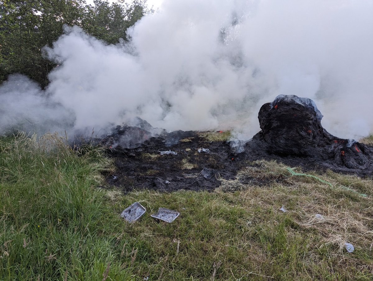 Tadley12's tweet photo. We're currently in attendance at an incident involving two large hay bales alight.... Can you spot the likely cause? 

#wildfire #amberalert #disposableBBQ https://t.co/N4PMHLatTy