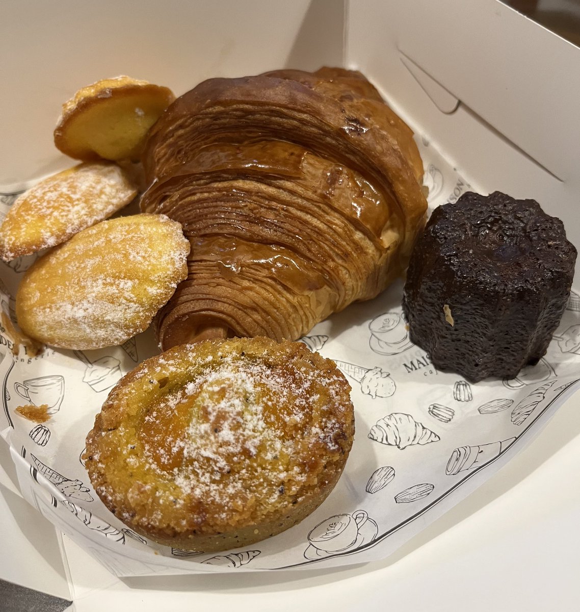 French pastries from maison des pains. Classic butter croissant, madeleines, french lemon poppy seed cake, and non-alcoholic canelé.