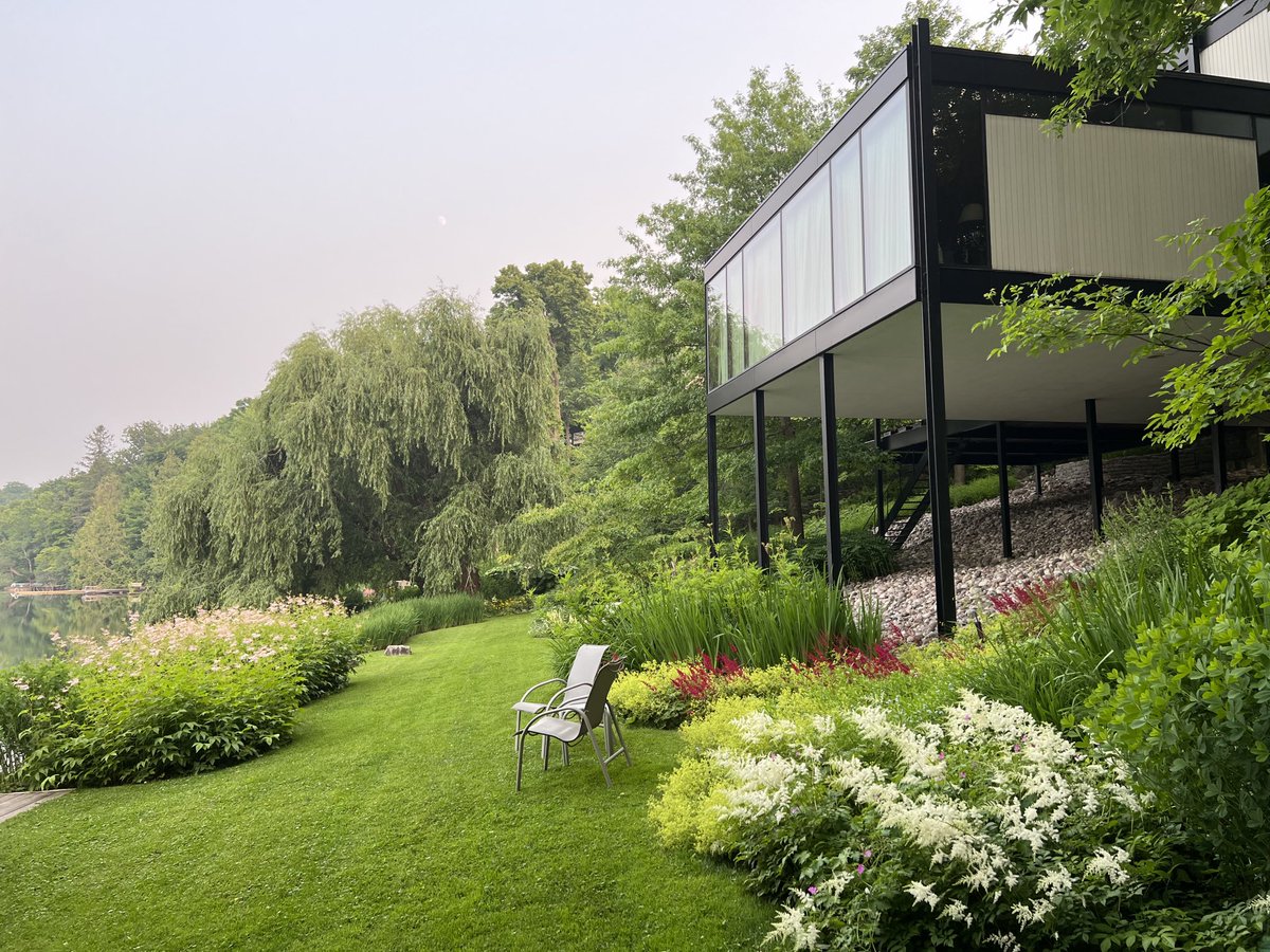 Thomas_dAquino's tweet photo. Early this morning in our #gardens looking south. The smokey sky does not take away from the beauty enhanced by #filipendula #astilbe and #lady’smantle #McKayLake #RockcliffePark #Ottawa #architecture. https://t.co/eWQeF7puJ8