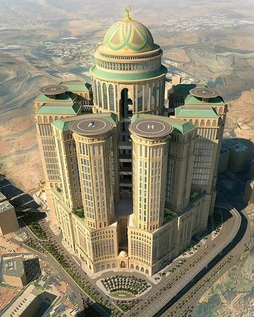 Este es el Abraj Kudai, el hotel más grande del mundo. 

Se encuentra en Arabia Saudita y tiene la increíble cantidad de 10,000 habitaciones, además de contar  con 4 helipuertos y la capacidad de alojar simultáneamente a 30,000 huéspedes.  Ocupa una enorme área de 1.4 millones de
