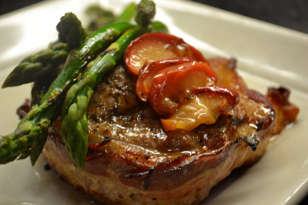 Apple smoked bacon wrapped Pork Chop with grilled asparagus.  Get ready for compliments all night long!
#porkchop #baconlove #yum