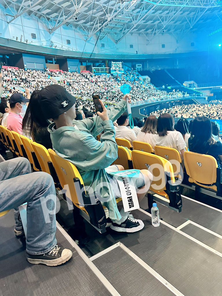 hoshi taking a photo of his shating star with the stage in the background 🥹