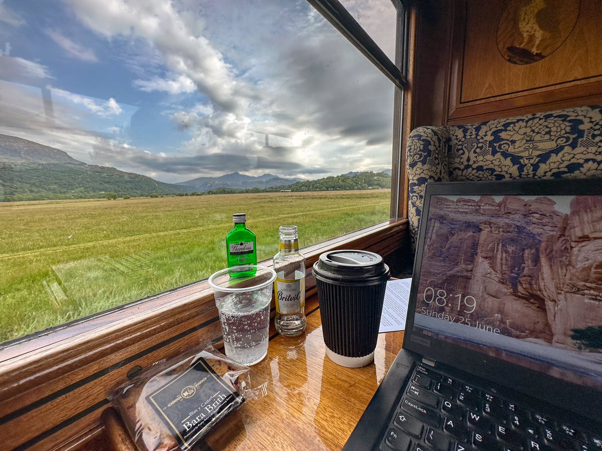 MrTimDunn's tweet photo. I’m working today: so am commuting aboard the 0800 WHR Porthmadog–Caernarfon. There’s a steam loco up front, at-seat service in this Pullman and we’re 1 min early. It’s like 1923, but with better tech. Happy 100th Birthday, Welsh Highland Railway! Cheers to all behind it. #WHR100 https://t.co/mPx4pG13DI
