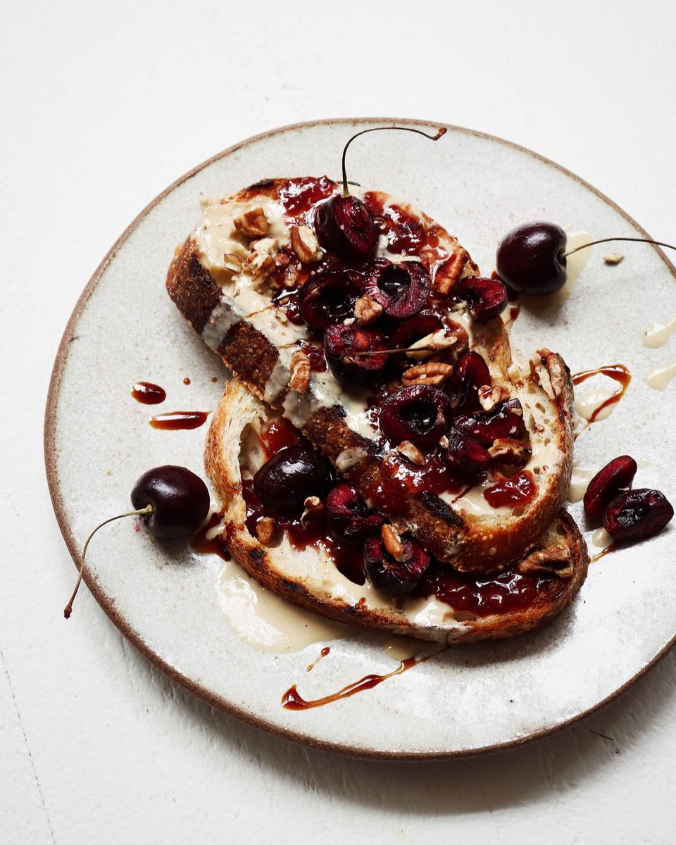 @breadalley presents a new age pb+ j: Tahini + cherry jam, a drizzle of date syrup and chopped toasted pecans. ​​​​​​​​ ​​​​​​​​ What are you topping your toast with lately? 🍒