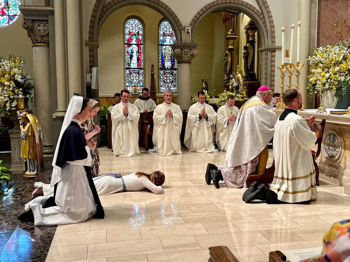 ShaneSchaetzel's tweet photo. This happened today in the Diocese of Lafayette, Louisiana. What you see here is a woman (lying prostrate) being consecrated as a virgin, living in the world. She will not be a nun. She will simply live among us as celibate. She has given up marriage, sex and children for Jesus Christ. Believe it or not, this is becoming more common these days. The intense perversity of our modern world, contrasted to the intense purity of Jesus Christ, is drawing more men and women to a life of celibacy.