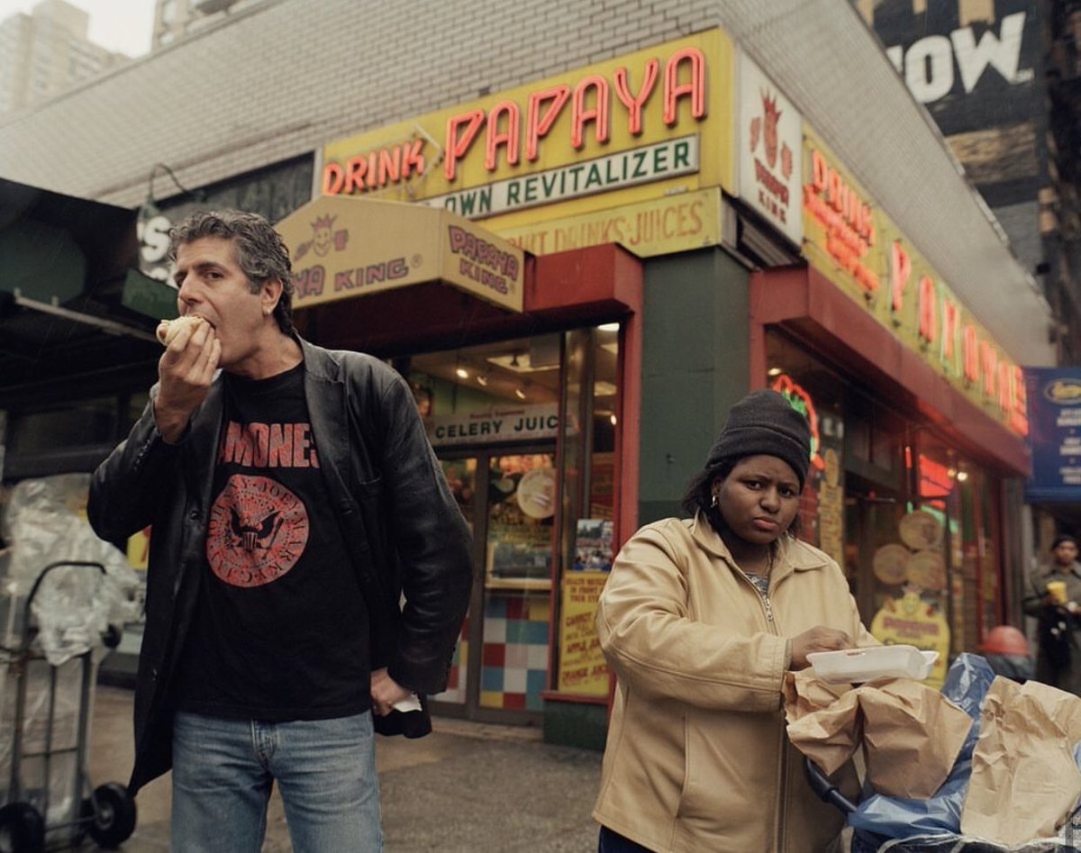 Anthony Bourdain 

stands outside of a New York restaurant in a Ramones t-shirt photographed by Jake Chessum