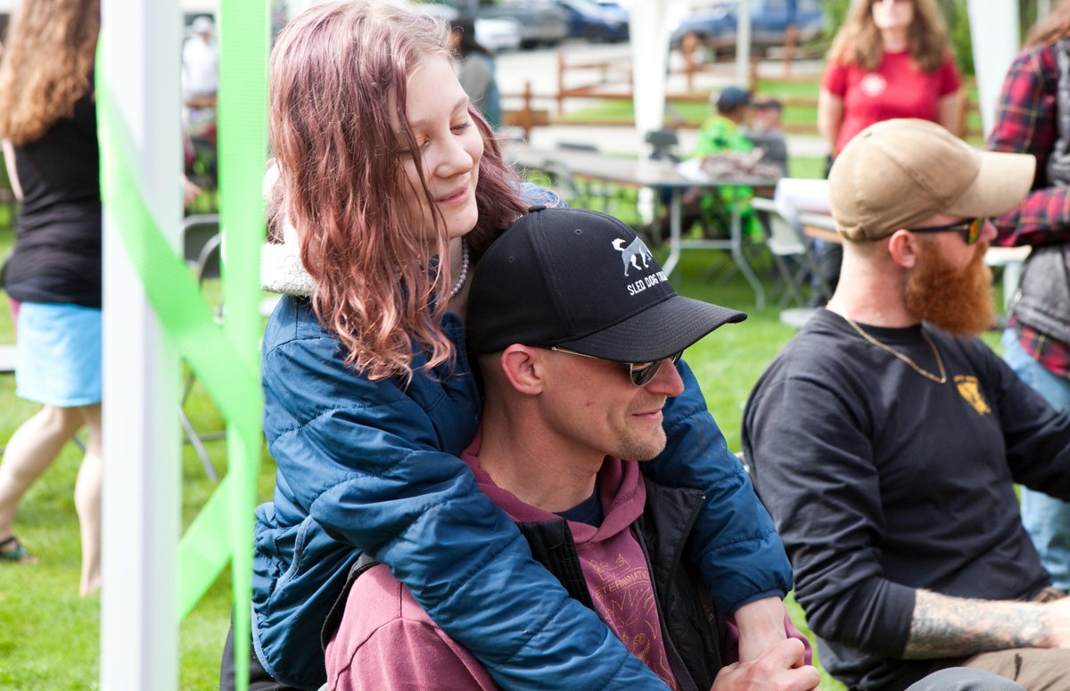 Dallas Seavey gets a playful hug from daughter Annie at the registration table for #Iditarod52. #IditaPicnic #Iditarod2024 #MusherTwitter #TeamSeavey