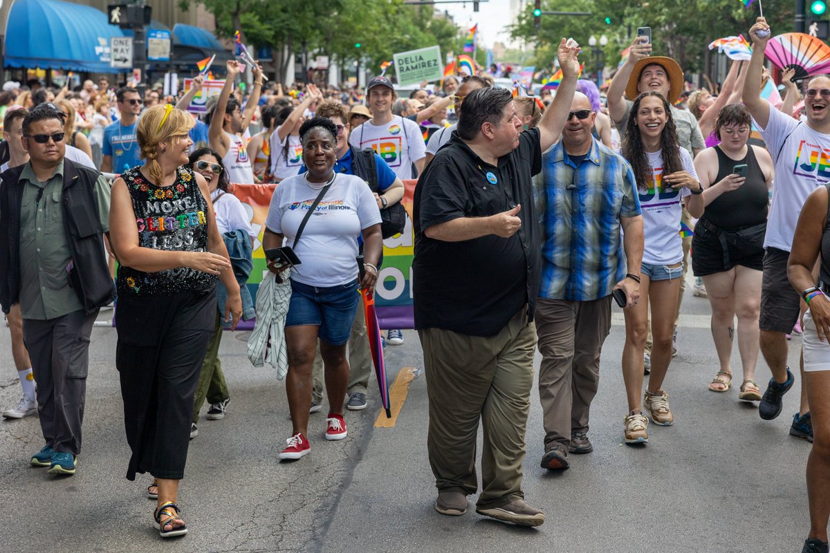 Governor Pritzker holds an empty cup and gives a thumbs up after catching and drinking a Jell-O shot with one hand today at the Chicago Pride Parade.