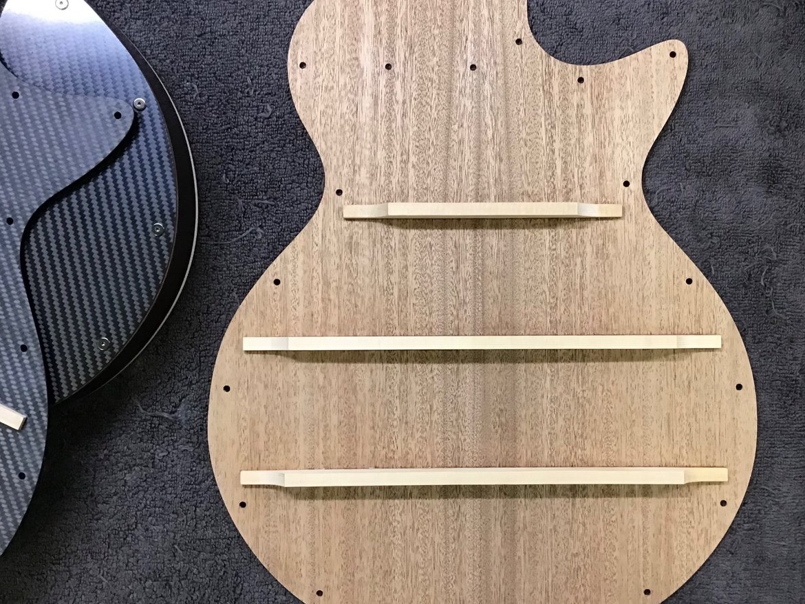 GenGuitarStudio's tweet photo. これが新素材 #CFaRP の開発研究の初期段階です。

#TestModel3 では様々な形状の空気層パターンの試作を行い、ボディバック板として使用する事でパターンによる違い、さらに木材との比較実験を行いました。

”張り”を持たせたCFaRPの反響音を確認するためのブレーシングが取り付けられています。 https://t.co/JHqtQdEGs2