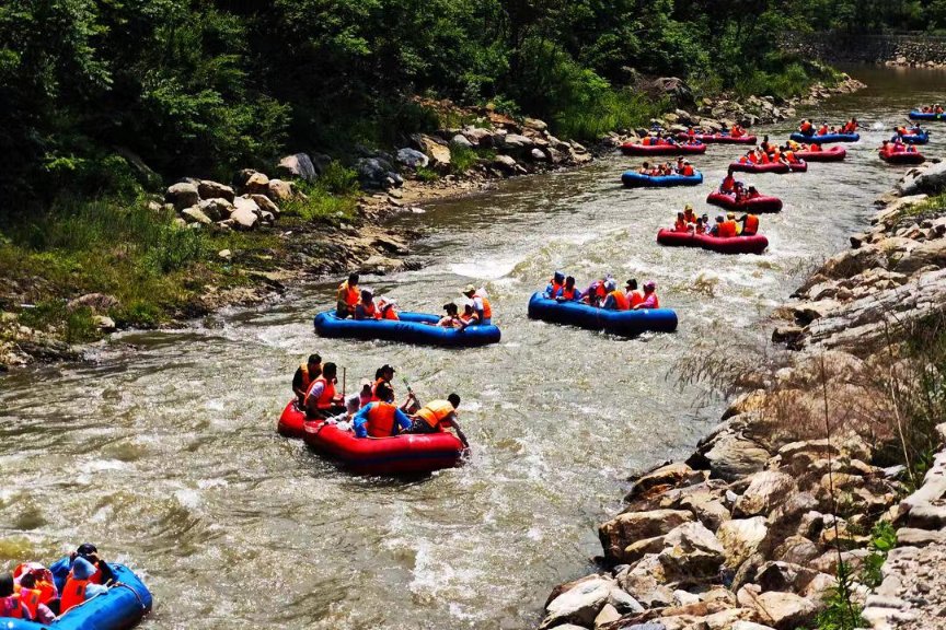 As the weather is getting hotter, more and more tourists come to the Dalian Tianmen Mountain National Forest Park to participate in the rafting activities and relieve summer heat.