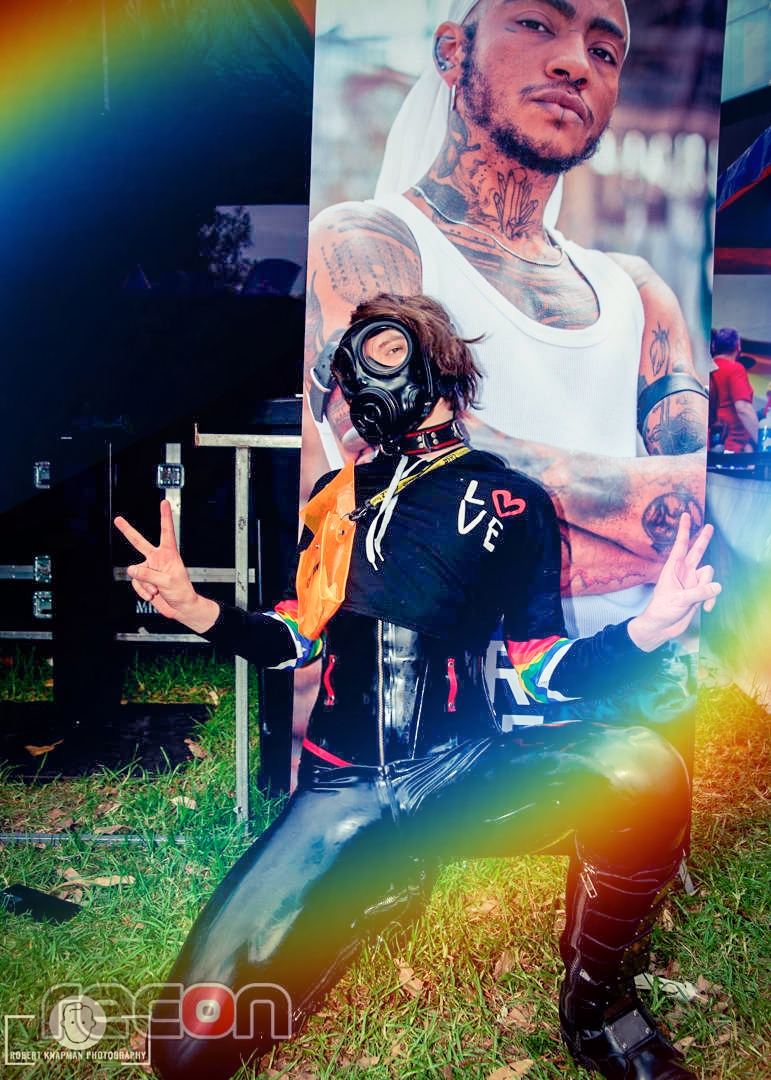 RubberlyChannel's tweet photo. @noirlatex paints the town rainbow at Sydney Mardi Gras Fair Day 2023! Pic credit @reconnews #Rubberly #LatexStyle #MardiGrasFairDay #RainbowEdit #RubberGasMask https://t.co/1ojjmS5miA