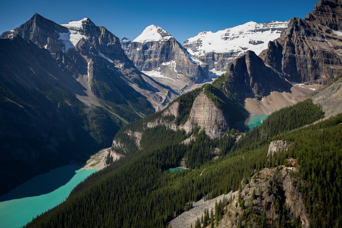 A unique aerial view of three well-known lakes of Banff National Park — Louise, Mirror and Agnes — and the surrounding peaks. What's your favourite hike in the Lake Louise region?