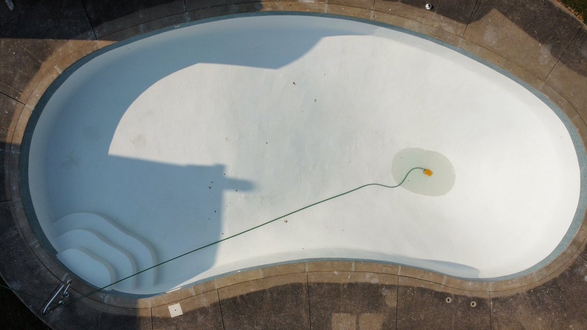 Reset old copings and installed a beautiful set of porcelain tiles, then Marblite troweled this old Fort Erie kidney pool, which now has life again. With our in-house marble blend, it will be gleaming white for years to come.