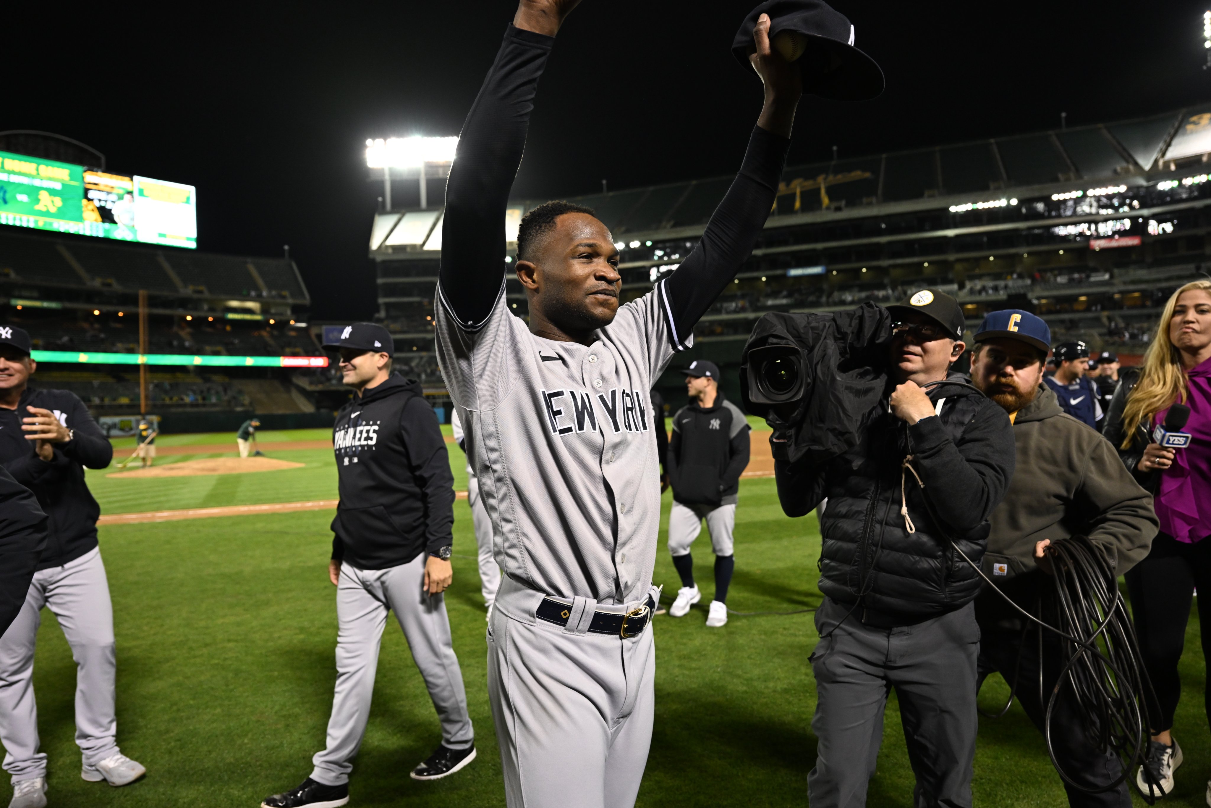 Domingo Germán raises his arms in triumph at Oakland Coliseum as he celebrates throwing the 24th perfect game in Major League history.