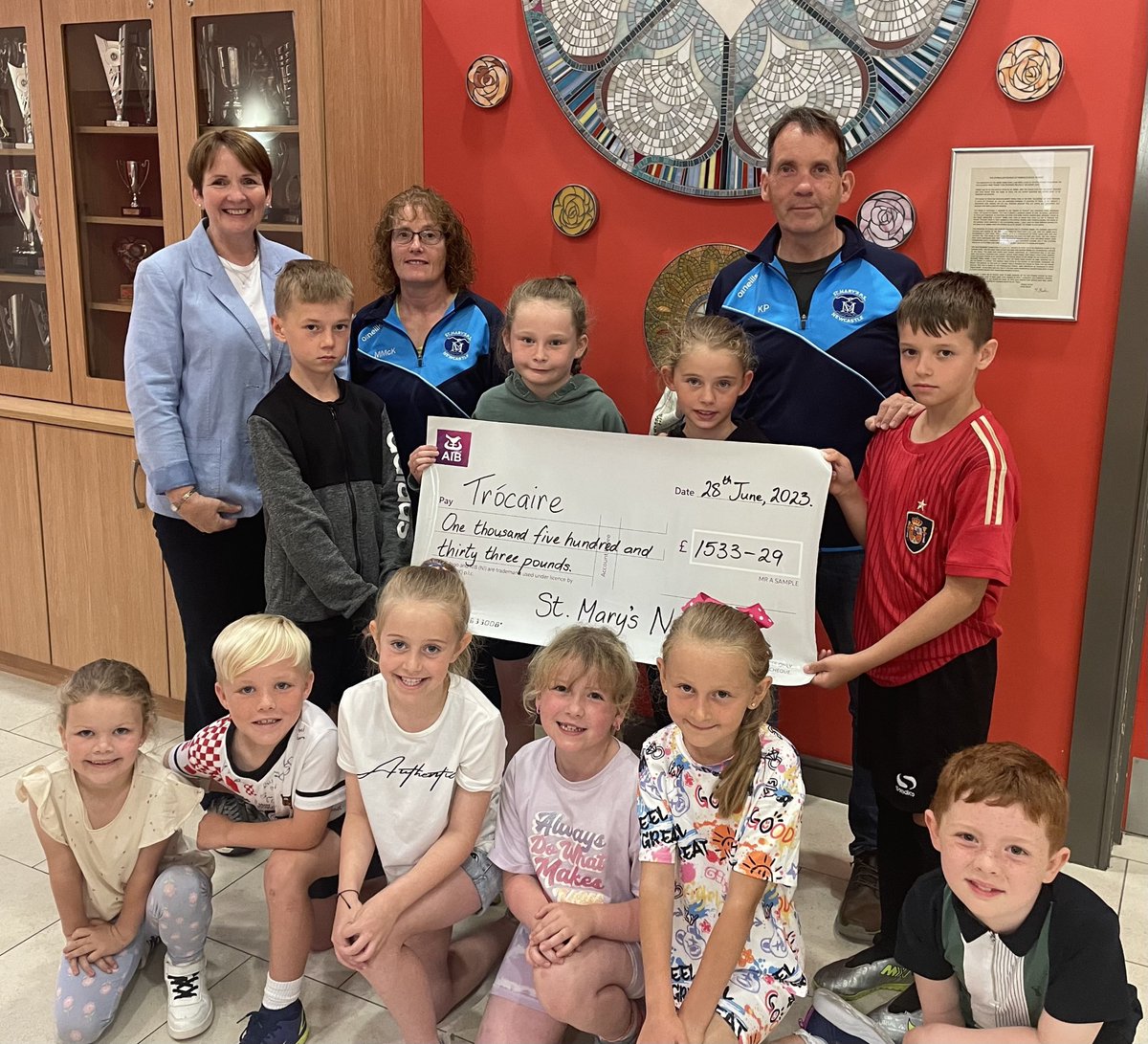 StNewcastle's tweet photo. Maria Jennings, Interim Head of Region, for Trocaire collected a cheque for £1533.39 from Mrs McAneney, Mr Prenter and some of our brilliant P3 and P5 children from our Lenten campaign.  @trocaire https://t.co/19mfpI2Keh